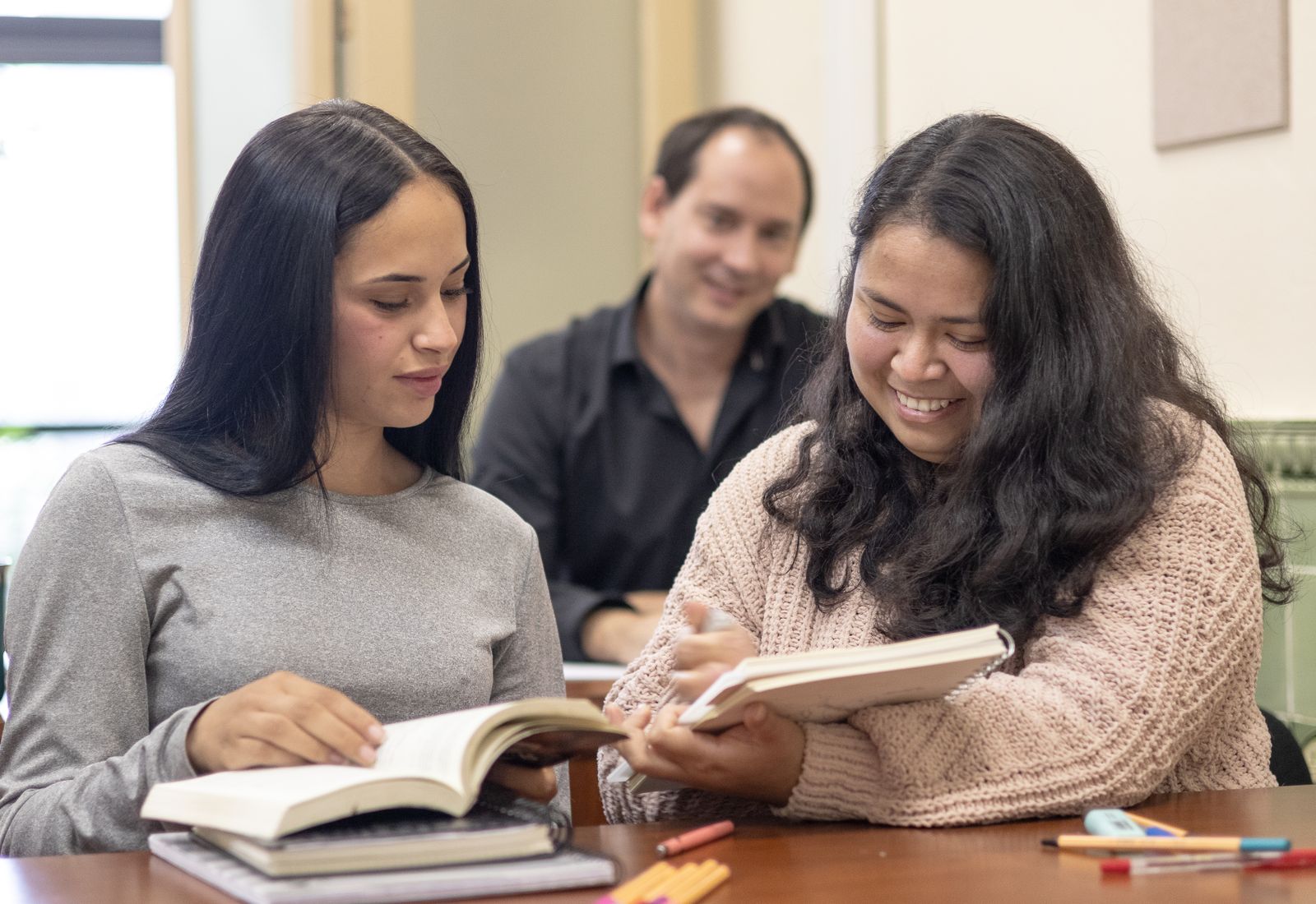 Two adult students studying together with a trainer